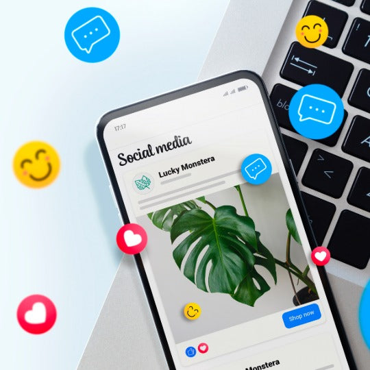 Smartphone displaying a social media app with a plant image, surrounded by social media icons and a keyboard. META ADs.
